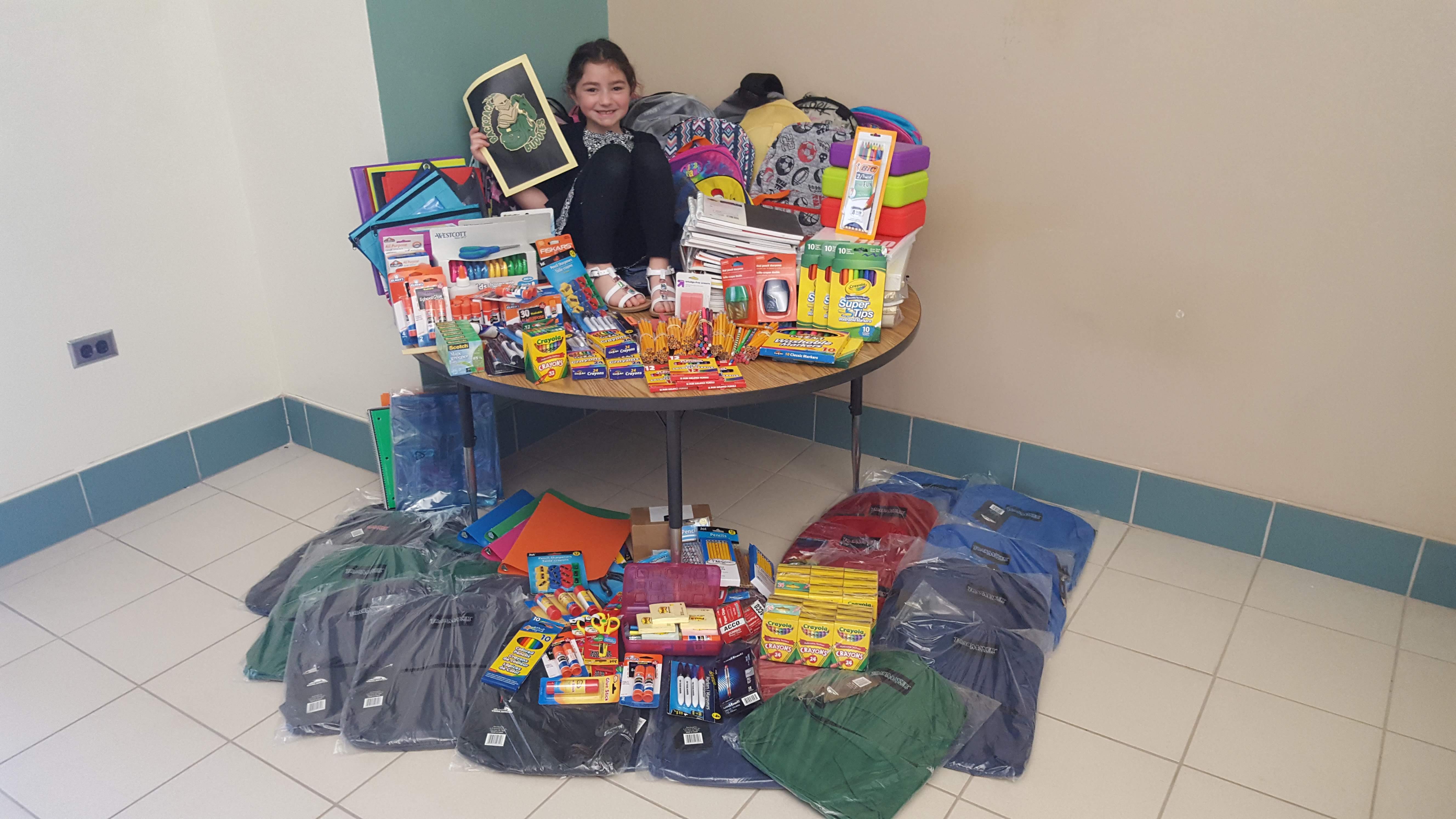 rylee surrounded by donated school supplies