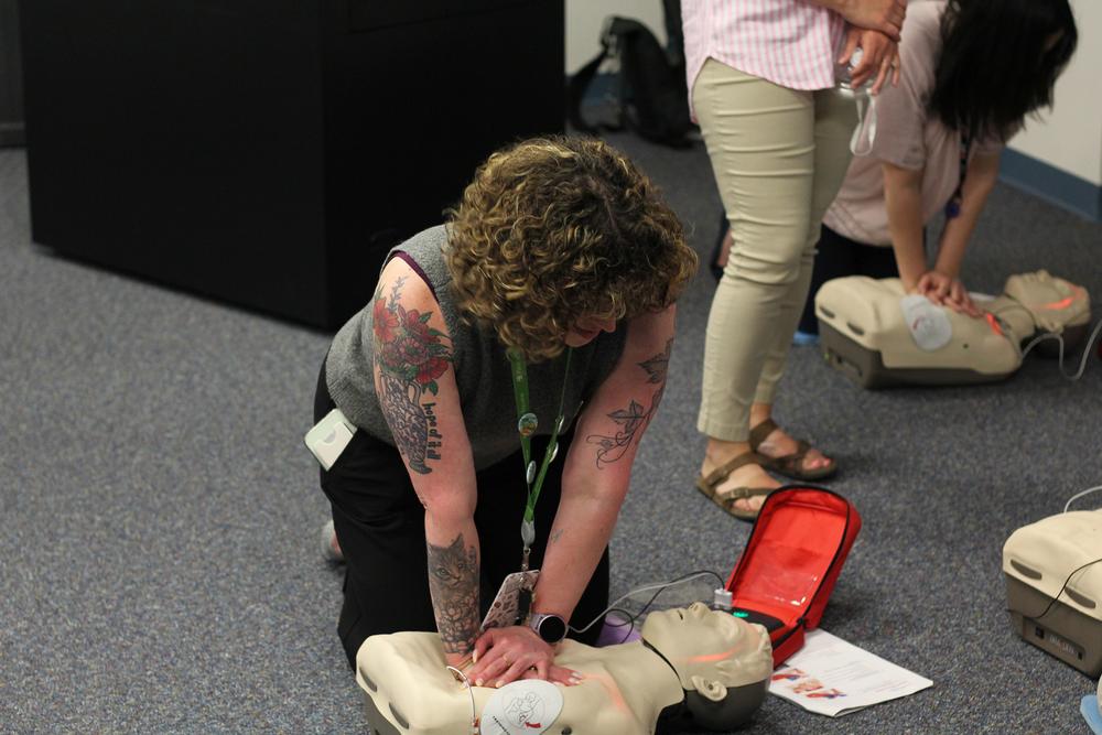 cnyric assistant director practices chest compression on training mannequin